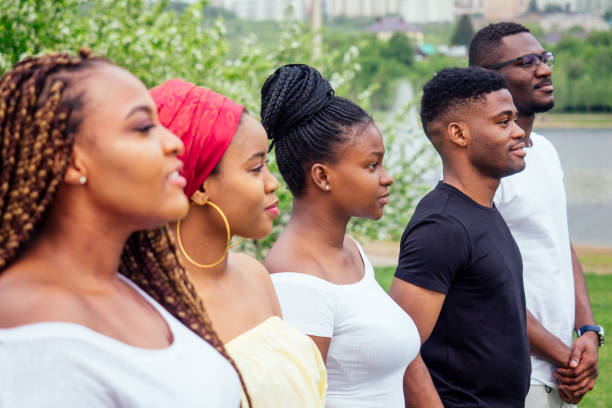 group of five smiling african-american men and women walking outside cloudy weather near the lake,exchange students in Russia