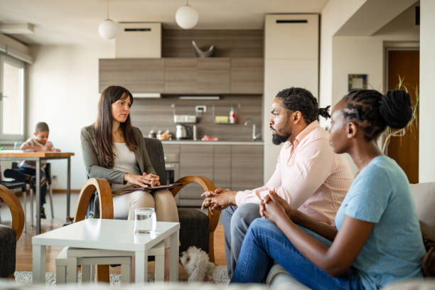 A family consulting with a professional counselor in a contemporary living room setting, discussing their needs and seeking guidance.